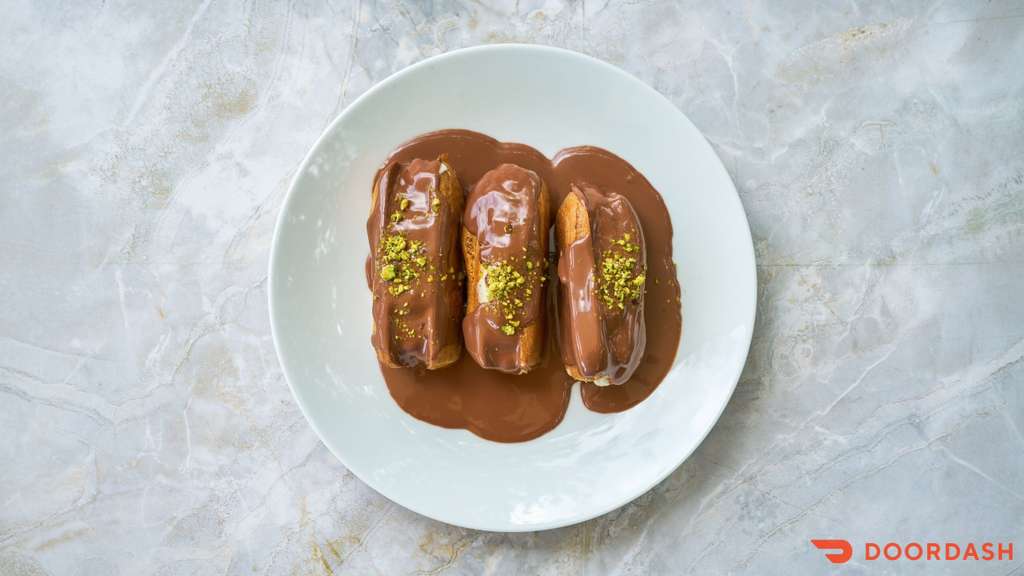 Chocolate Éclair — Classic French choux pastry filled with vanilla cream, topped with chocolate glaze.